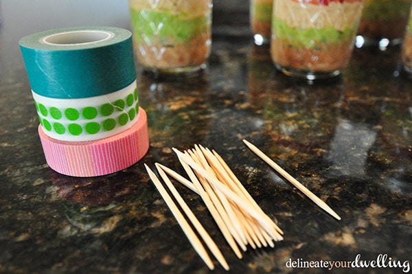 Celebrate Cinco De Mayo by creating adorable mason jar Five Layer Dip appetizers to enjoy at your festive holiday celebration! Delineate Your Dwelling #5layerdip #CincoDeMayo
