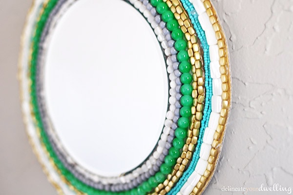 Learn how to create a stunning Round Beaded Wall Mirror using only a few simple materials! Hang this colorful DIY Mirror on the wall to admire every day. Delineate Your Dwelling #beadedwallmirror #roundwallmirror #DIYbeadedmirror