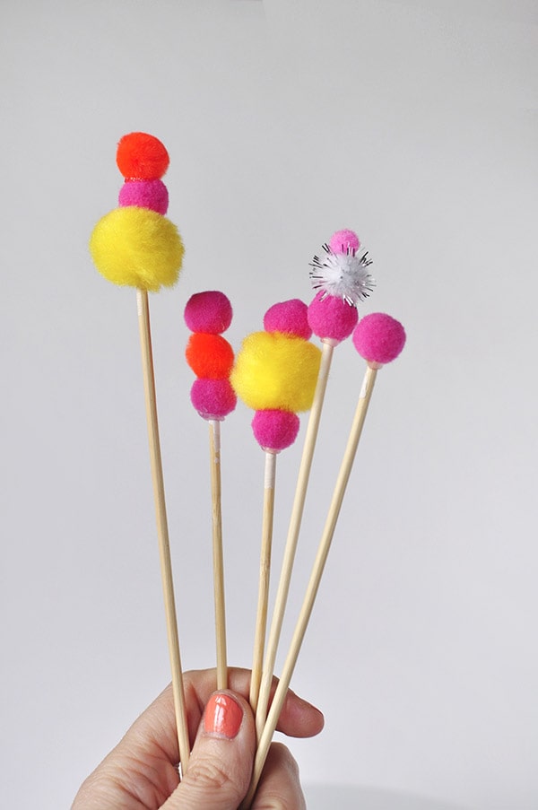 Adorable and simple, see how to create this Pom Pom Birthday Cake Topper for your next party!  Fun Banner Cake Toppers make celebrations so much more fun and they are easy to add to any dessert. Delineate Your Dwelling #pompombirthdaycake #pompomcaketopper #birthdaytopper #pompomcake