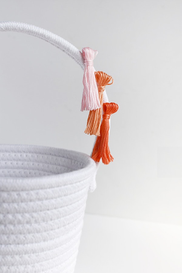 First, learn how to make tassels using Embroidery Floss. Then apply those tassels to any type of basket, making a simple and fun DIY Tassel Easter Basket for Easter this year! Delineate Your Dwelling #easterbasketDIY #tasselbasket #DIYEasterBasket #DIYEaster