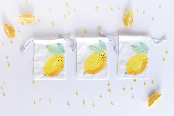 Learn how to paint fun refreshingly easy DIY Painted Lemon Bags! They are great to give as gift bags, teacher gifts or just told tasty treats. Perfect for summer fun. Delineate Your Dwelling #paintlemon #lemonbag #fruitcraft