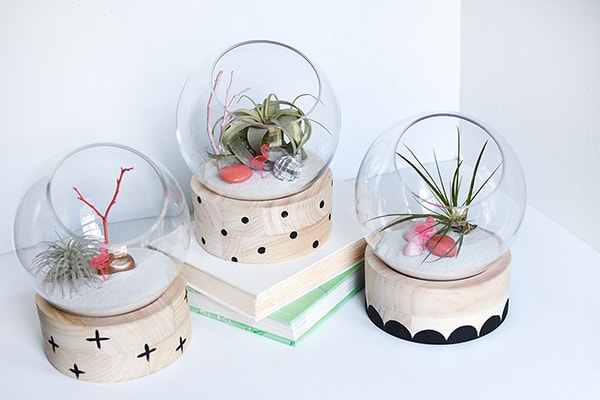 A modern take on a traditional plant terrarium! Painted Crosses, Scallops and Polka Dots add the perfect pattern to the wood base.  Learn how to create this trendy DIY using air plants, disco balls and mini flamingos. Delineate Your Dwelling #modernterrarium #airplantterrarium