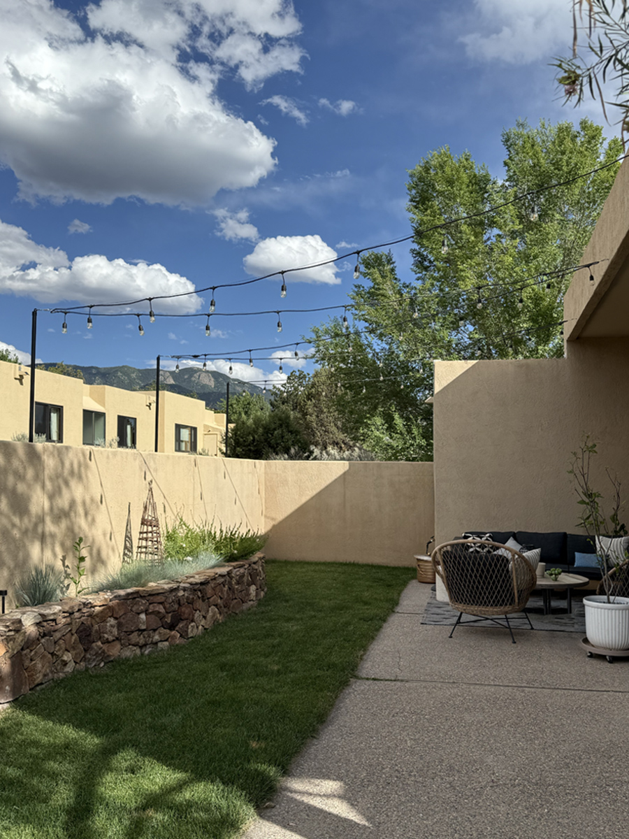 Green dessert Stucco Walled Backyard with string lights