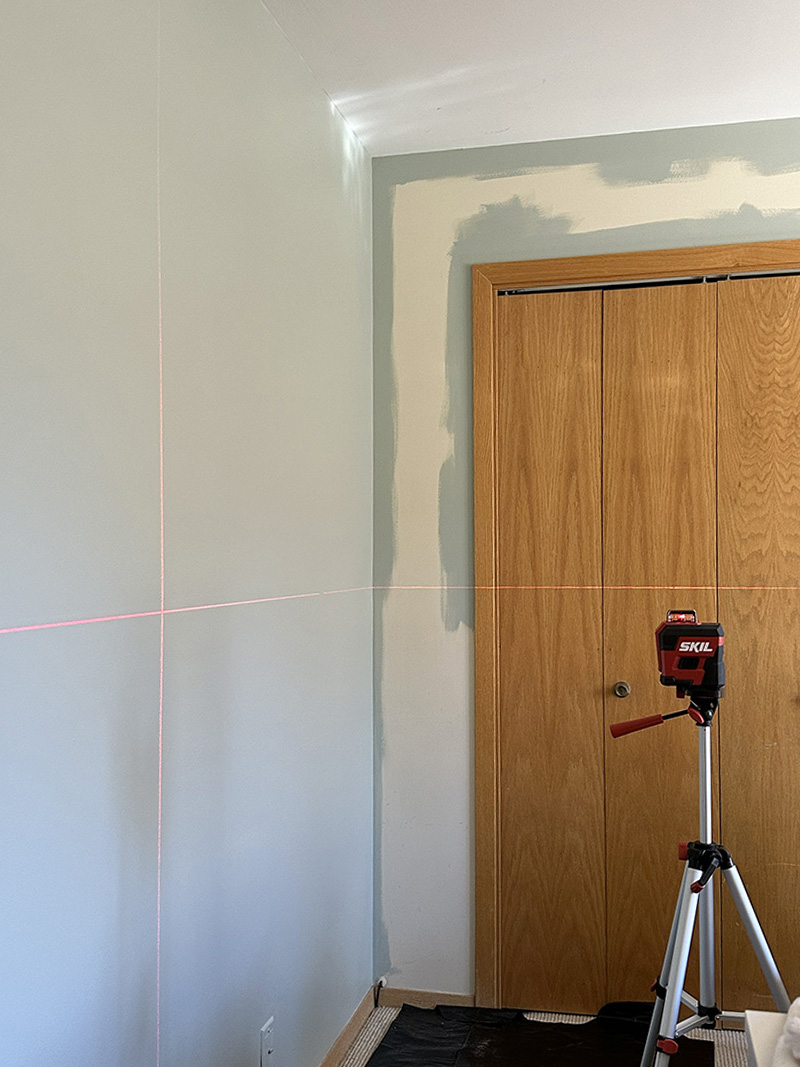 Laser level on sage green wall