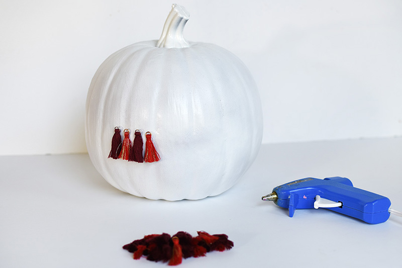 Plain white pumpkin with four red tassels