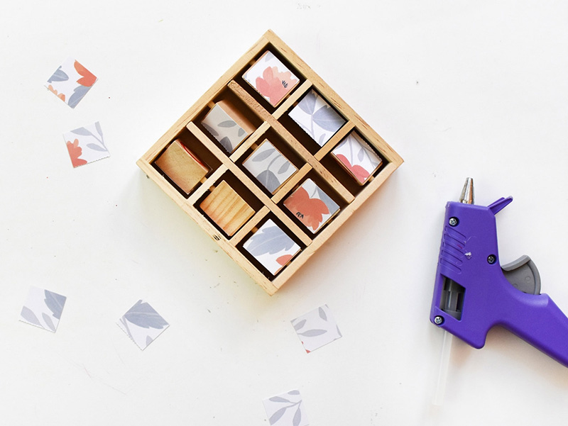 Gluing scrapbook paper onto wooden games with a hot glue gun