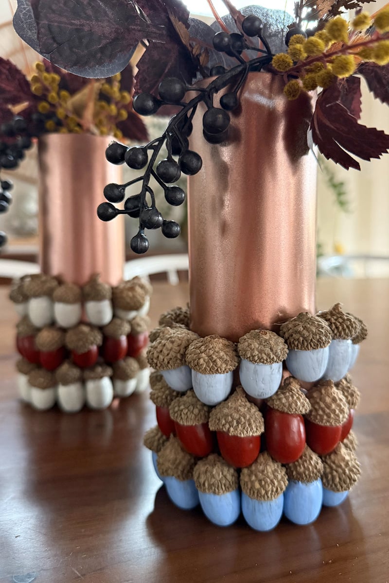 Blue, red and light blue painted acorns on a copper vase