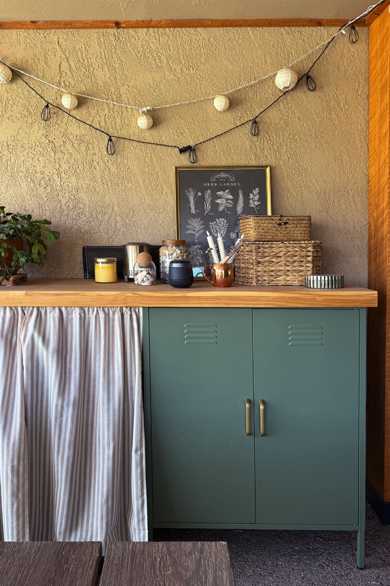 DIY Wooden outdoor bar top over metal lockers and a striped cafe curtain