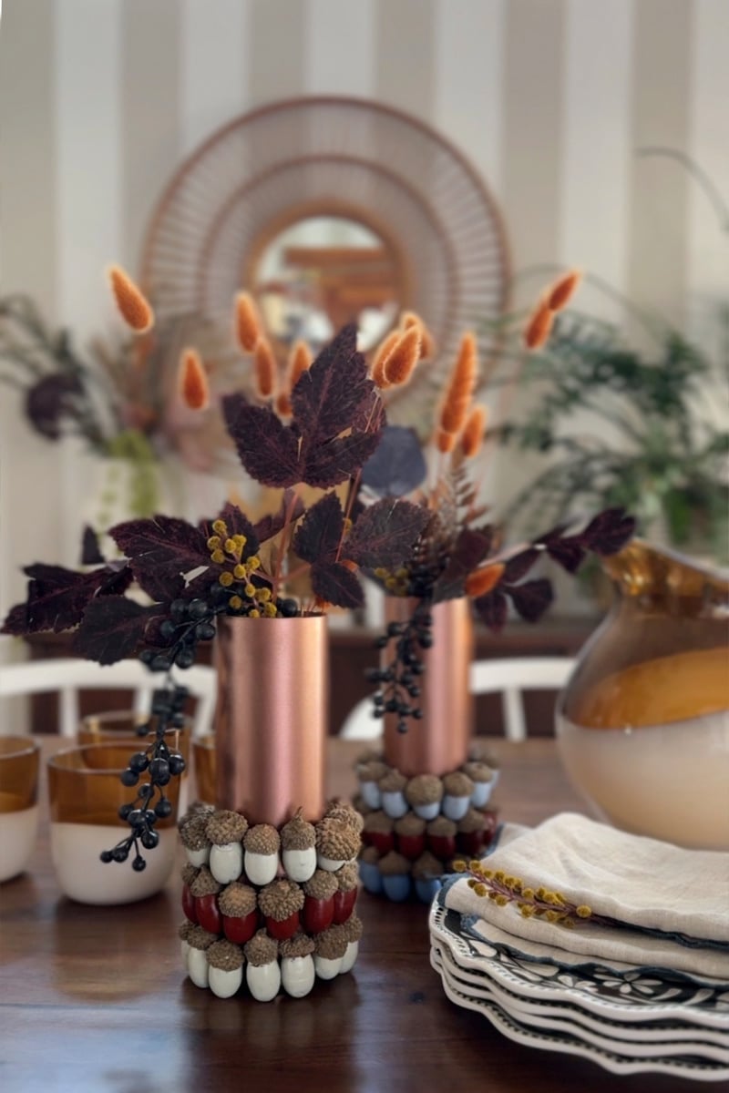 Cozy and warm colors on a painted acorn Fall centerpiece displayed on a table
