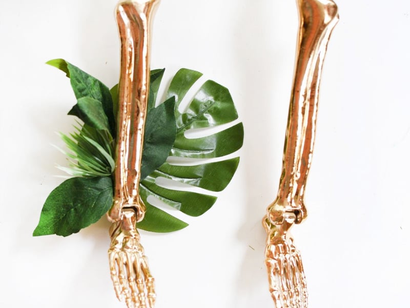 Monstera leaves and greenery glued onto gold skeleton leg