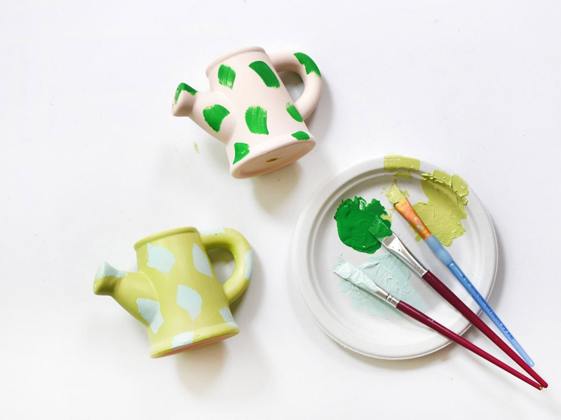 Raw ceramic watering cans in green and mint dash patterns