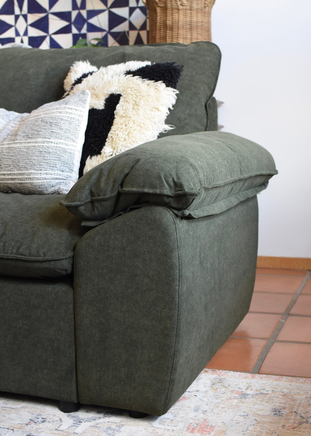 Plush nap pillow top armrest on green sofa