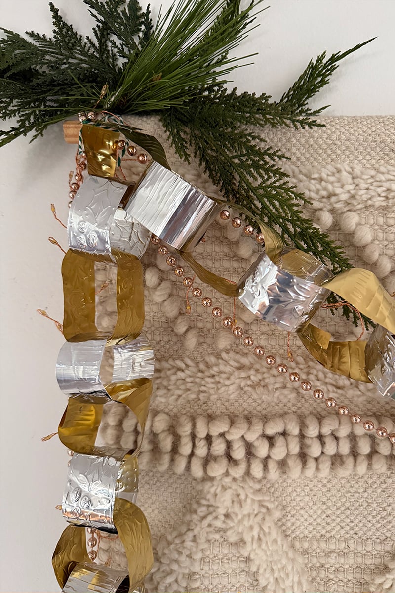 Silver and gold embossed metal garland with evergreen bough