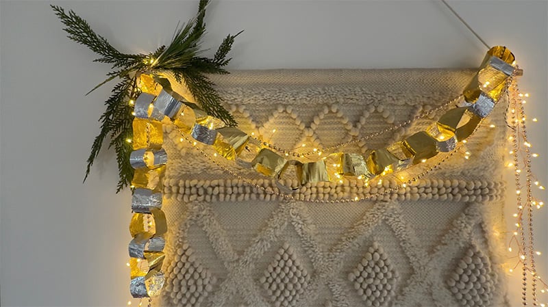 Twinkle lights and Christmas metal garland hung on tapestry