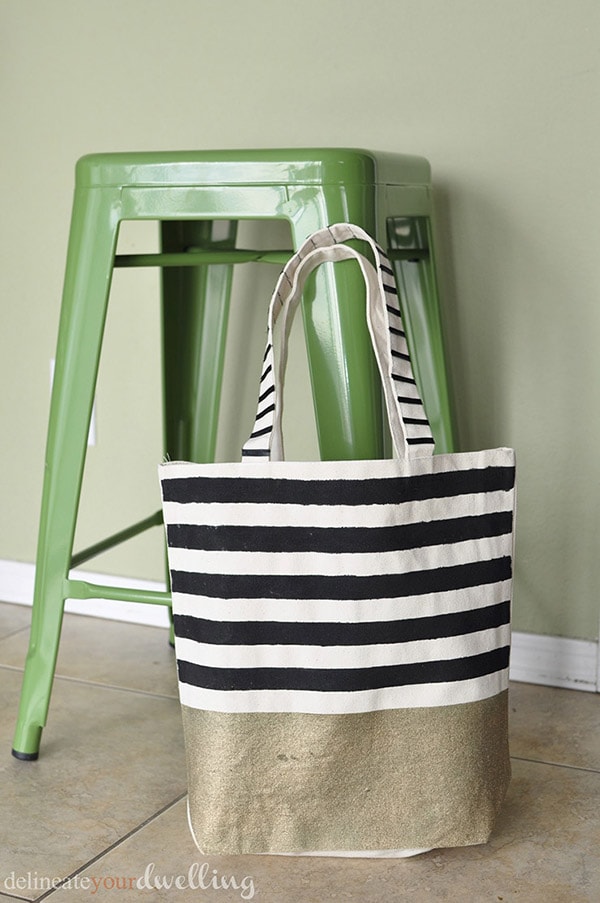 Learn how to create a gorgeous DIY Striped West Elm inspired tote bag! Perfect for carrying your miscellaneous items around in style. Delineate Your Dwelling #stripedtotebag #canvastotebag #DIYcanvastote