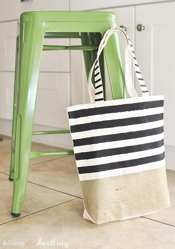 Learn how to create a gorgeous DIY Striped West Elm inspired tote bag! Perfect for carrying your miscellaneous items around in style. Delineate Your Dwelling #stripedtotebag #canvastotebag #DIYcanvastote