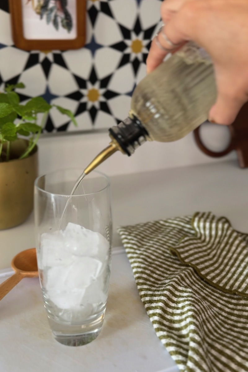 Simple syrup poured into glass with ice