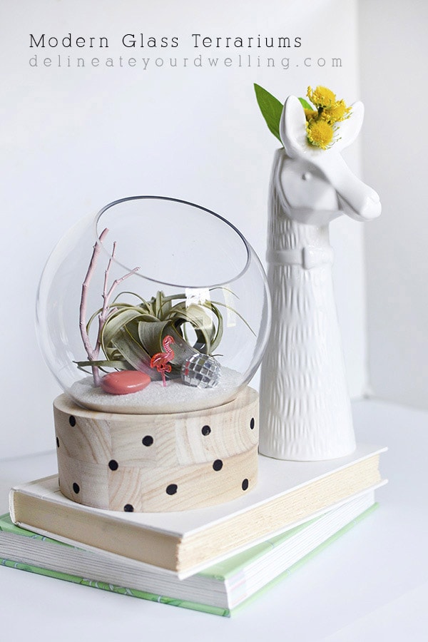 A modern take on a traditional plant terrarium! Painted Crosses, Scallops and Polka Dots add the perfect pattern to the wood base.  Learn how to create this trendy DIY using air plants, disco balls and mini flamingos. Delineate Your Dwelling