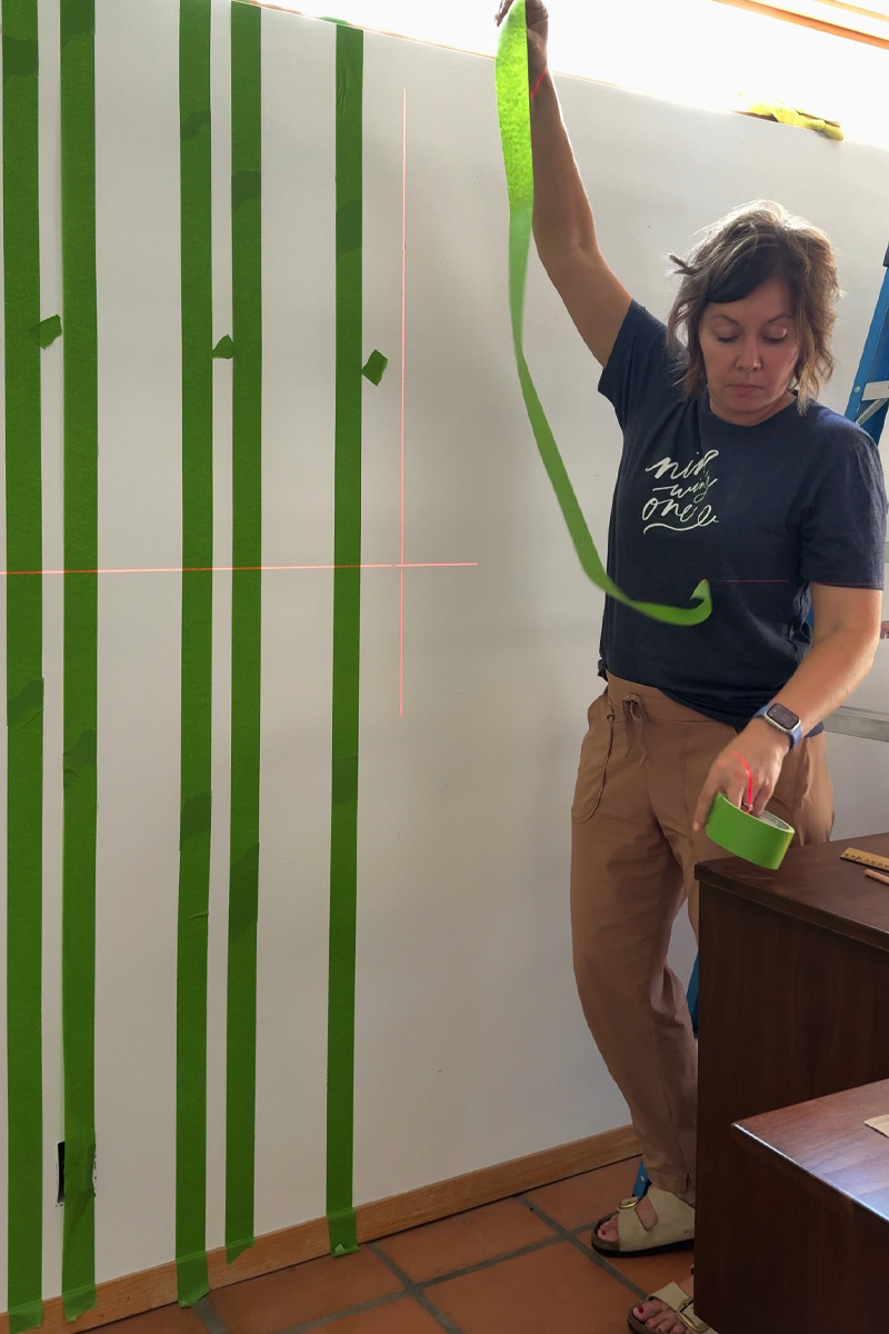 Applying painter's tape to wall