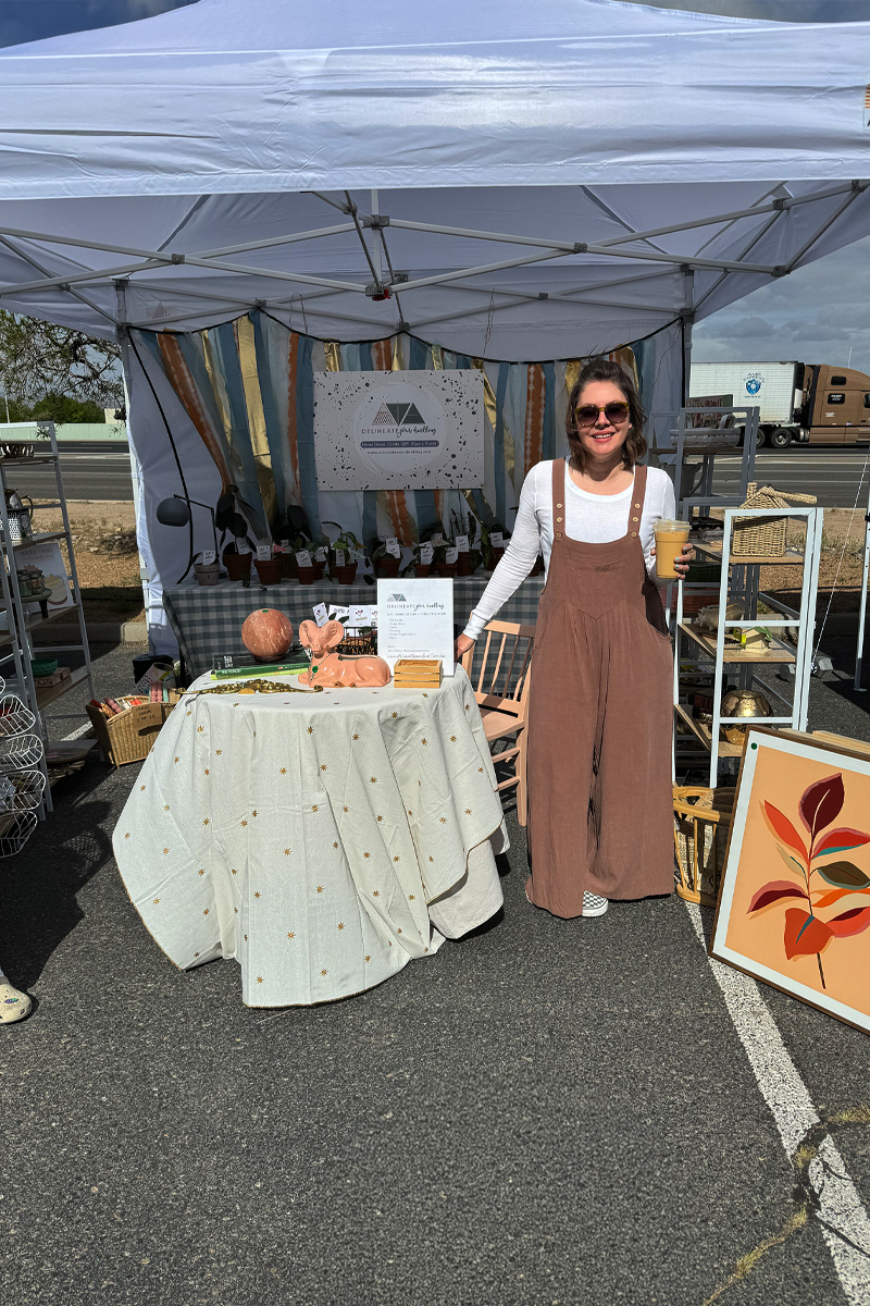 Cute woman holding a coffee in her home decor craft show booth tent