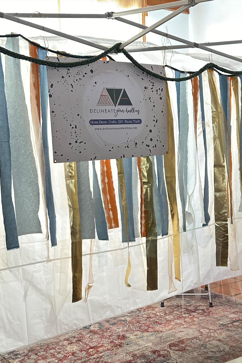 DIY Ribbon backdrop and company sign for a popup event tent