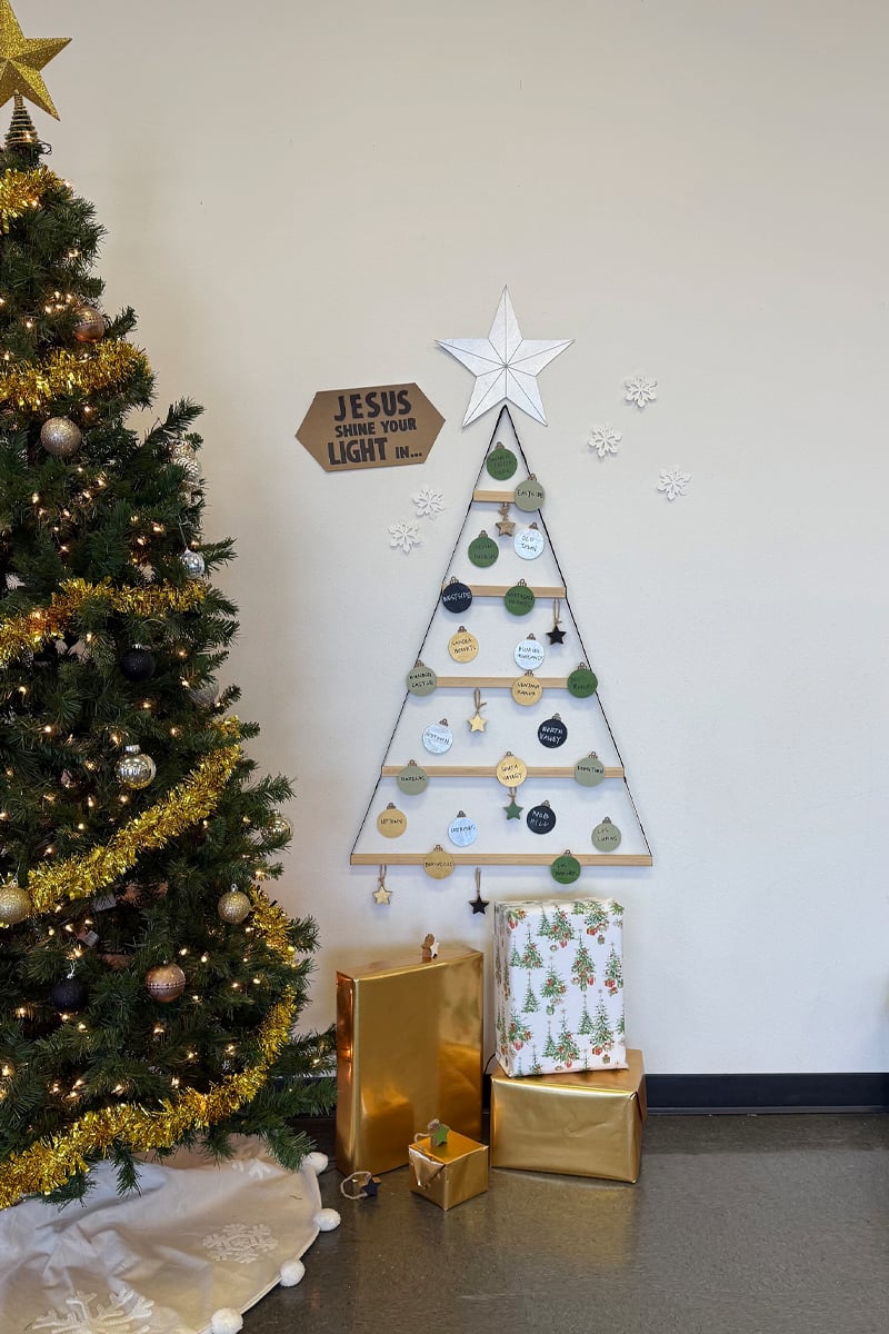 Jesus Shine Your Light sign beside a ribbon Christmas tree