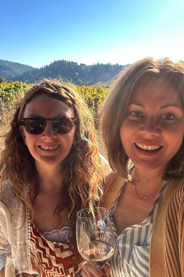 Two woman standing near grape vines at vineyard in Healdsburg, CA