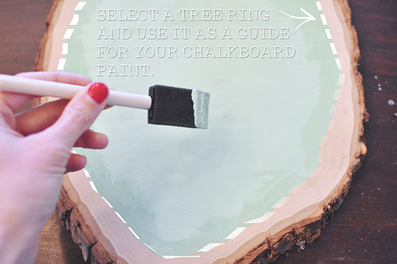 Painting mint green chalkboard paint on a tree slice