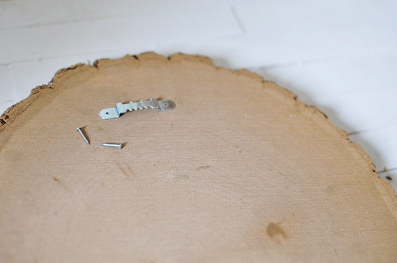 Picture Hanging hooks on the back of a tree slice