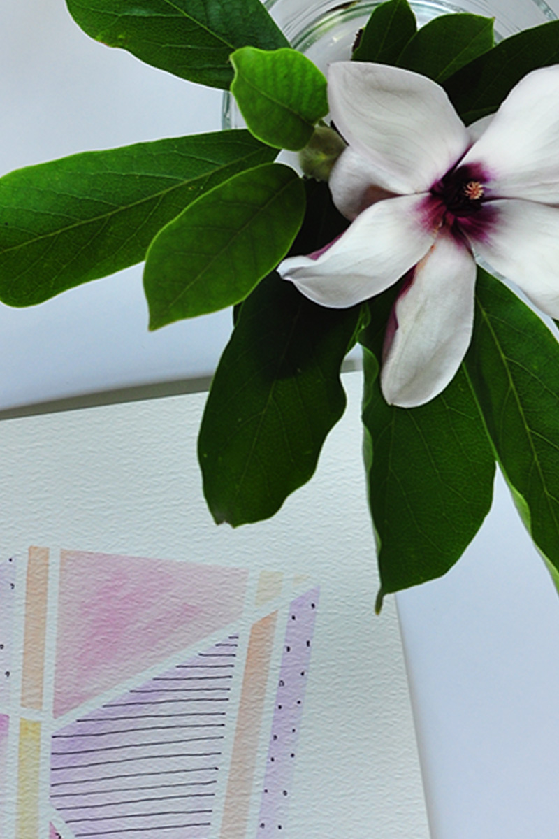 Magnolia flower beside a watercolor painting